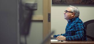 seated person staring at a screen in profile